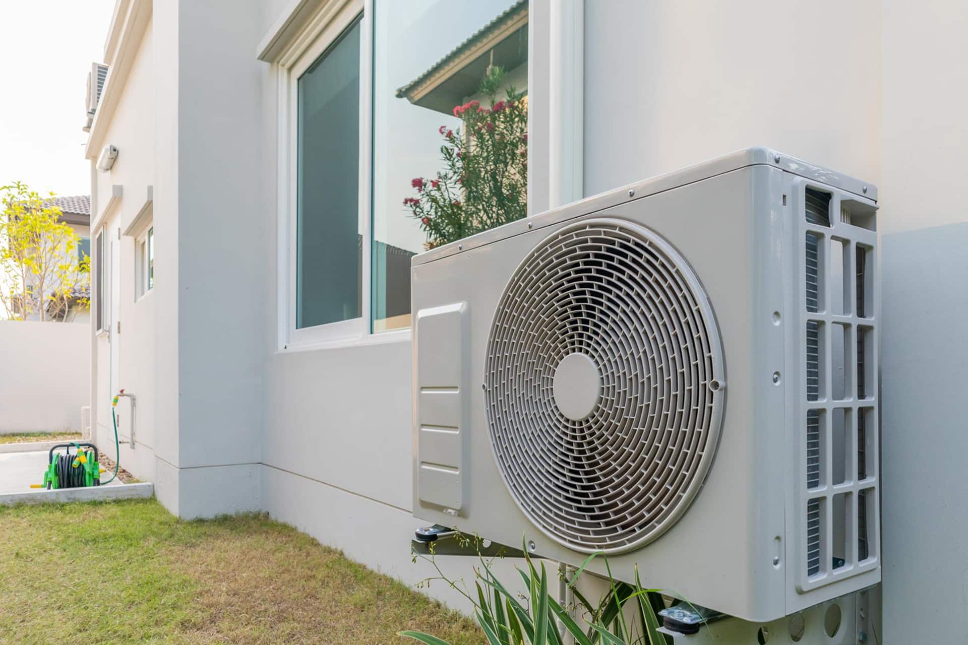 outdoor air conditioning unit mounted on house wall residential HVAC system